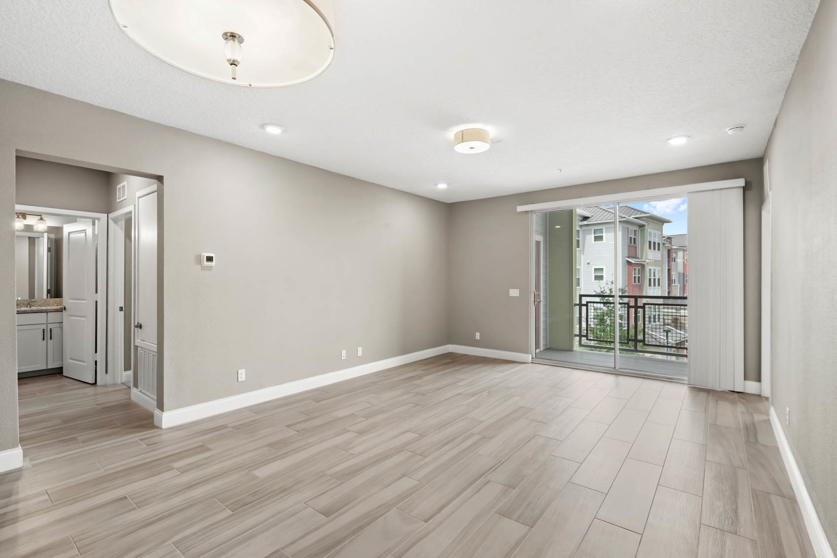 living room with windows to private balcony and hallway